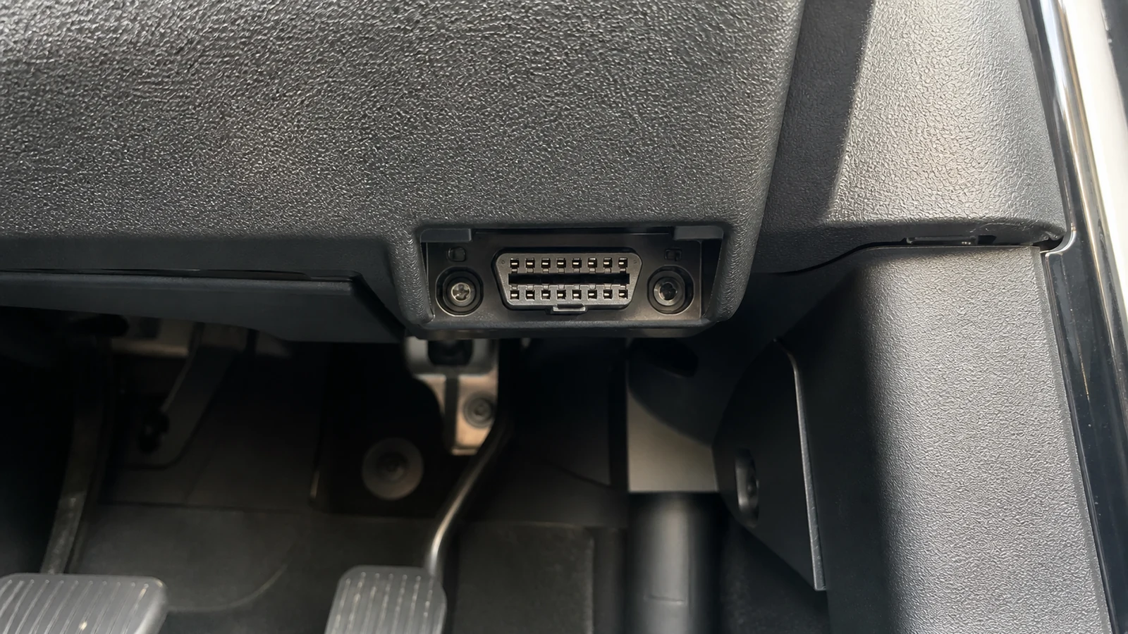 16-pin EOBD diagnostic port under a right-hand-drive car dashboard